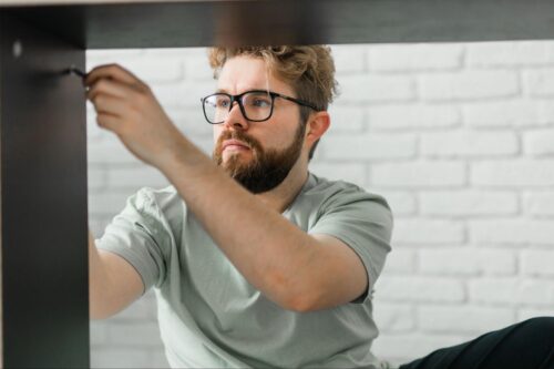 Young man assembling a fitted wardrobe